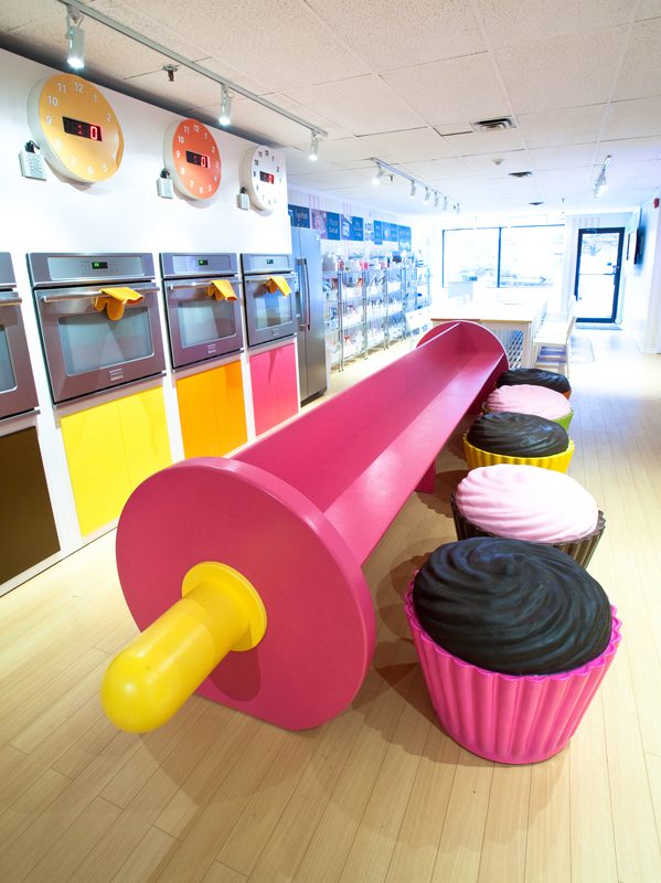 A hot pink rolling pin and cupcake chairs feature in this "Willy Wonka meets Baking" pop-up bake shop.