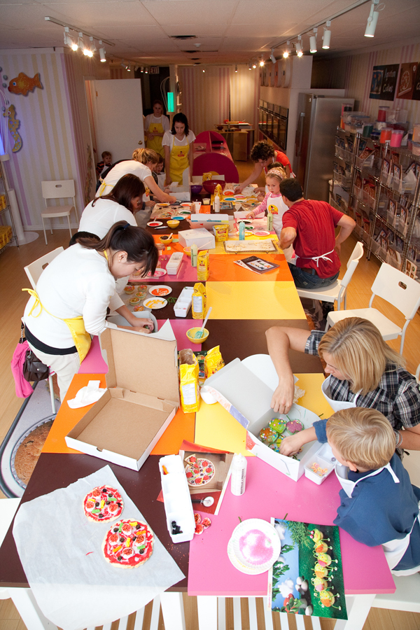 Kids and their parents having fun baking their treasures.